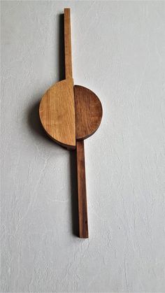 a wooden spoon and spatula hanging on the wall with white walls in the background