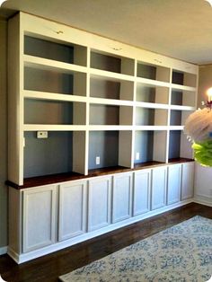 a living room filled with lots of white bookshelves