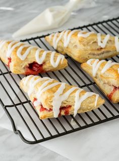 pastries with icing sitting on a cooling rack