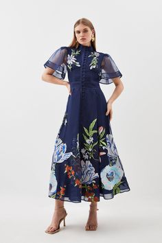 Ornate And Original, This Midi Dress Is Defined By Intricate Embroidery To The High-Neck Bodice, Offset By Semi-Sheer Long Sleeves And Tonal Buttons. Landing At A Delicately-Gathered A-Line Skirt, This Wedding-Ready Piece Calls For Tonal Stilettos And An Artful Floral Headband.High Necktonal Buttonsfloral Embroiderymidi Length Botanical Motifs, Botanical Embroidery, Dark Dress, Guest Attire, Colour Pop, Wedding Attire Guest, Angel Sleeve, Navy Midi Dress, Sleeve Midi Dress