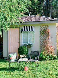 a small house with a table and chairs in the yard