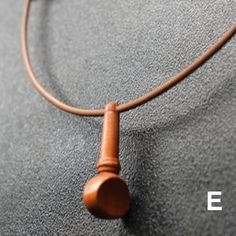 a wooden object is hanging from a leather cord