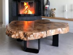 a wood table with a fire burning in the fireplace