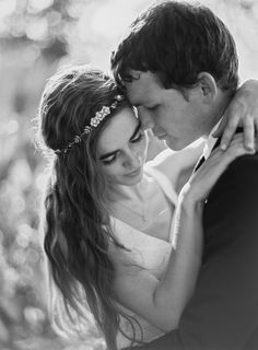 a bride and groom embracing each other in black and white