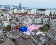 an aerial view of a city with lots of tall buildings and colorfully painted walls