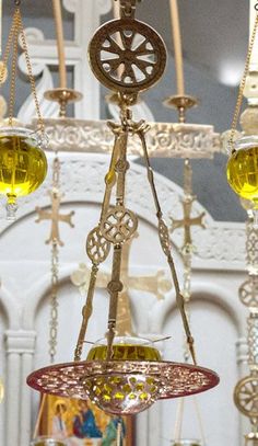 an ornate chandelier with three lights hanging from it's sides in a room