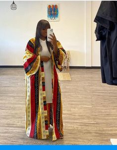 a woman taking a selfie with her cell phone in front of clothes on display