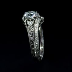 an antique style diamond engagement ring with filigrees