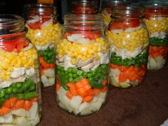 several mason jars filled with different types of vegetables