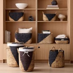 three baskets are sitting on the floor in front of some bookshelves