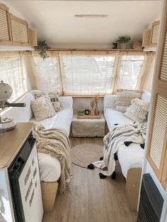 the interior of a small camper with two beds and a kitchenette in it