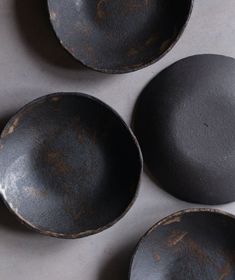 four black bowls sitting on top of a table