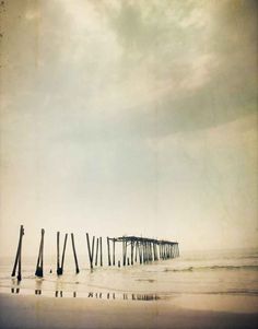 an old photo of a pier in the ocean