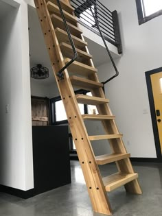 a wooden stair case with metal railing and handrails in a loft style home