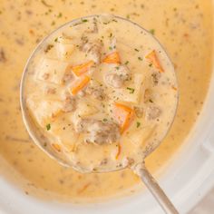 a ladle filled with soup on top of a white plate