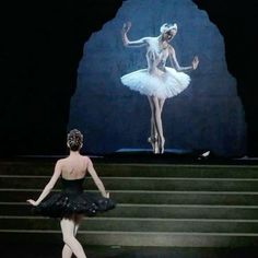 a ballerina is standing on the steps in front of a stage with an image of a dancer