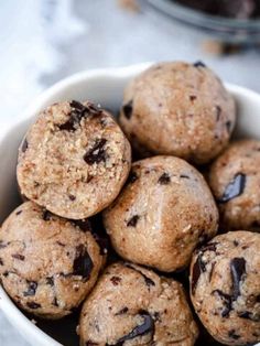 a white bowl filled with chocolate chip cookie doughnuts on top of a table