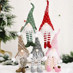 three christmas gnome ornaments hanging from a tree