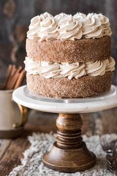 a cake with white frosting sitting on top of a wooden table