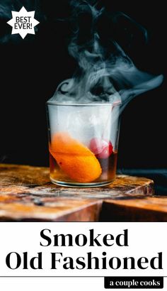 a glass filled with liquid sitting on top of a wooden cutting board