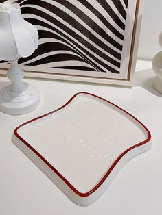 there is a white and red square plate next to a black and white zebra print