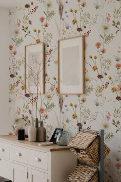 the wallpaper in this room is very colorful and has flowers on it, as well as two framed pictures