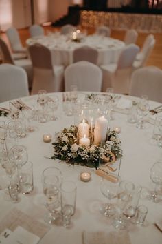 the table is set with candles, flowers and wine glasses for an elegant wedding reception