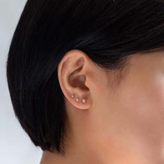 a close up of a person's ear with two piercings on the side