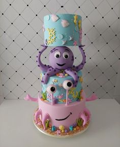 a three tiered cake decorated with an octopus and sea creatures on it's side