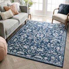 a living room with couches, chairs and rugs