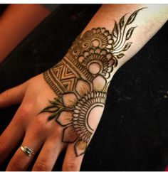 a woman's hand with henna tattoos on it