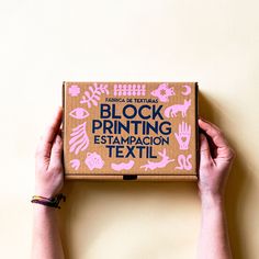 a person holding up a box that says block printing estamppacon textil