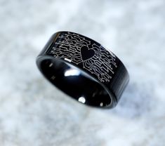 a black wedding band with an etched heart on the inside and inlaid to it