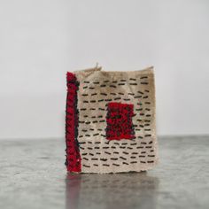 a red and black object sitting on top of a table next to a white wall