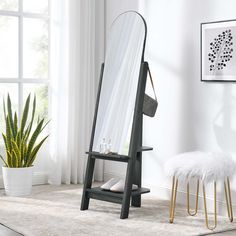 a mirror sitting on top of a wooden stand next to a potted plant in a room