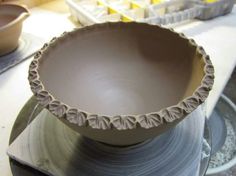 a clay bowl sitting on top of a potter's wheel