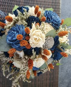 a bridal bouquet with blue, white and orange flowers