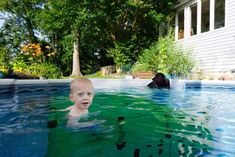 a young boy swimming in a pool with his head above the water's surface