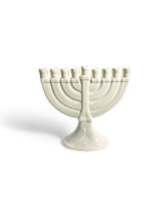 a white ceramic menorah with eight candles on it's stand, set against a white background