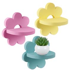 three flower shaped hangers in different colors and shapes, one with a succulent plant