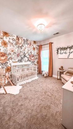 a baby's room with floral wallpaper and a crib in the corner