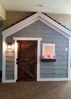 there is a doll house with a wooden door and window on the side of it