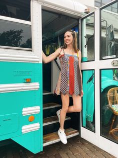 a woman standing in the open door of a bus