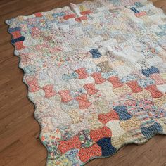 an old quilt is laying on the floor