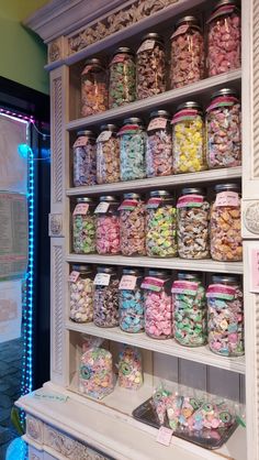 a display case filled with lots of different kinds of candies and candy in glass jars