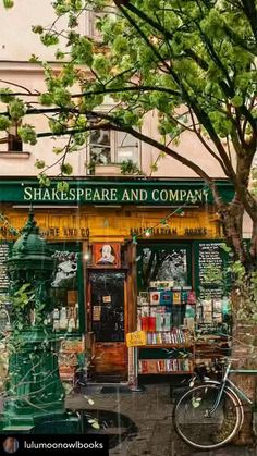 a green fire hydrant sitting in front of a book store next to a tree