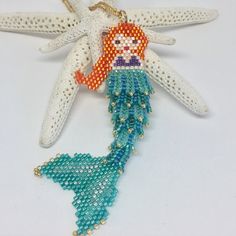 an ornament shaped like a starfish with a little mermaid on it