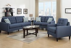 a living room with blue couches and chairs in front of a large glass window