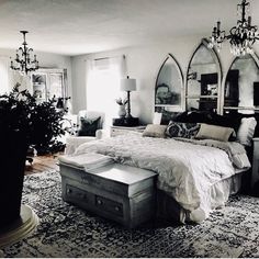 a bedroom with a large bed and chandelier