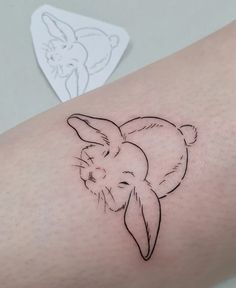 a small tattoo on the arm of a person with a rabbit head drawn on it